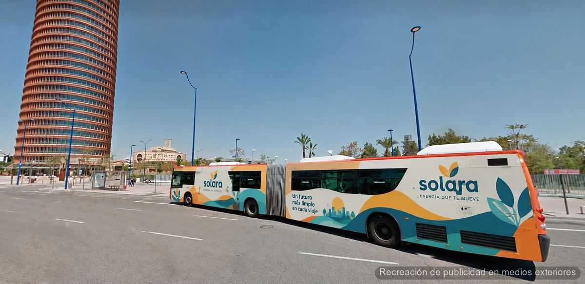 Autobús articulado de TUSSAM rotulado con publicidad integral junto a la Torre Sevilla